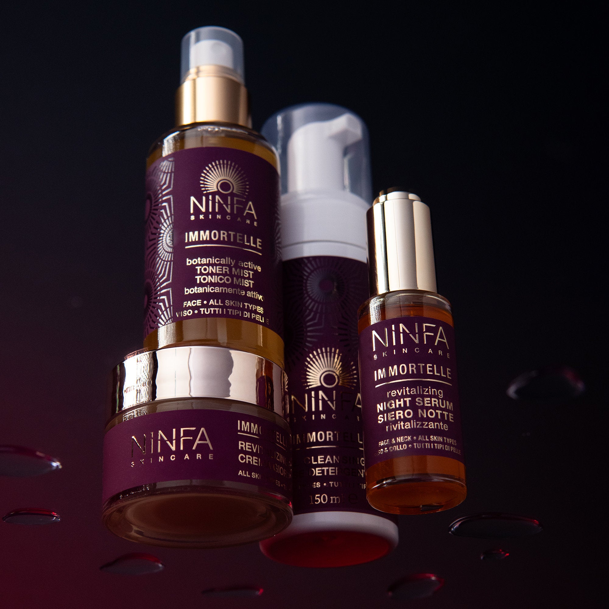 Set completo skincare rivitalizzante anti age all’elicriso di Ninfa Skincare su vetro con gocce e sfondo viola scuro"