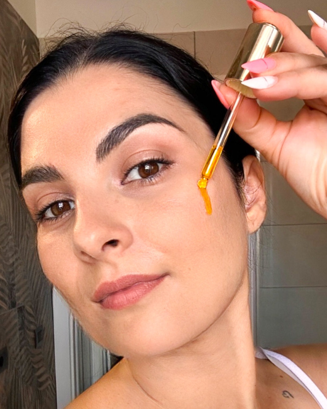 Donna con siero all’elicriso di Ninfa Skincare, trattamento viso anti age naturale