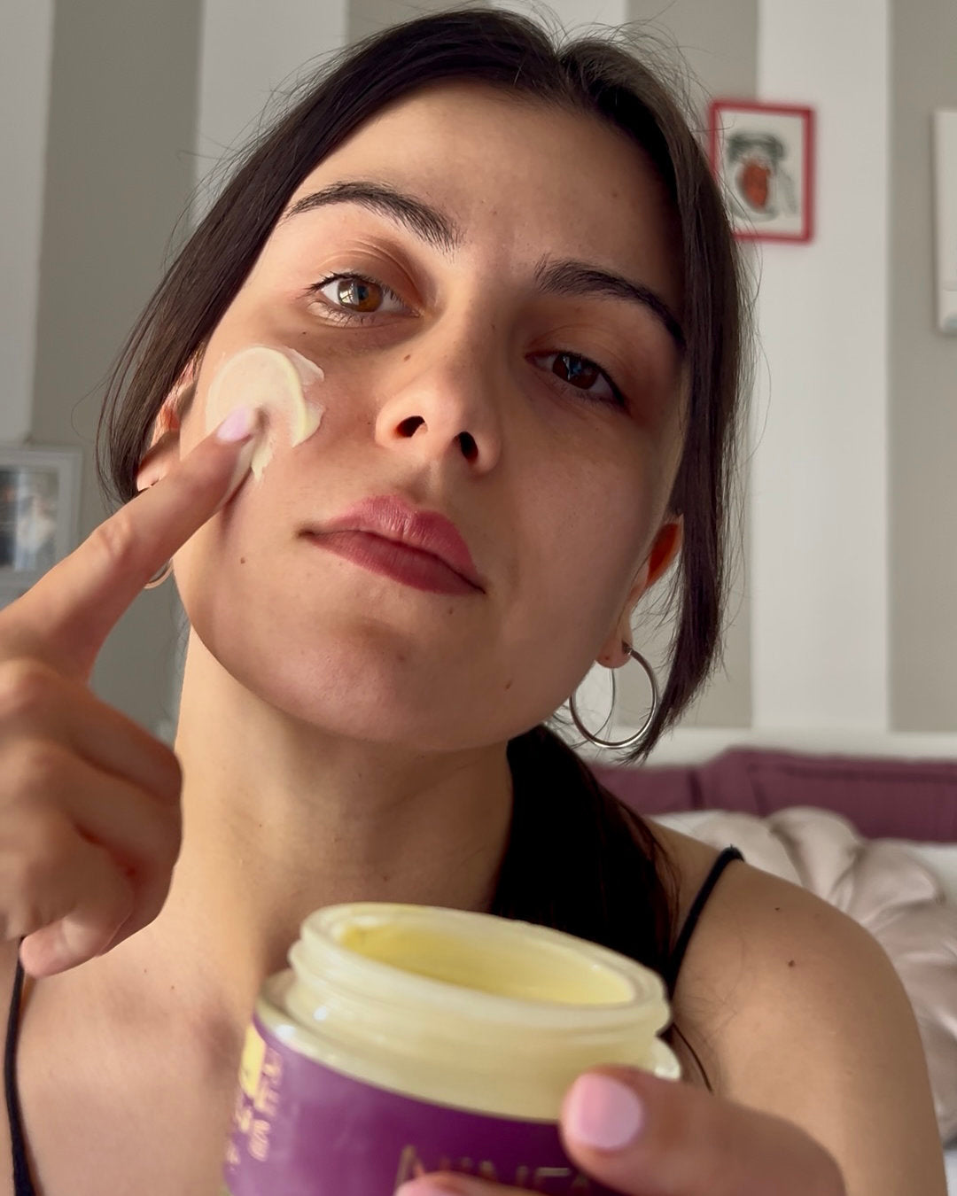 Donna con crema viso all’elicriso di Ninfa Skincare, trattamento viso anti age naturale