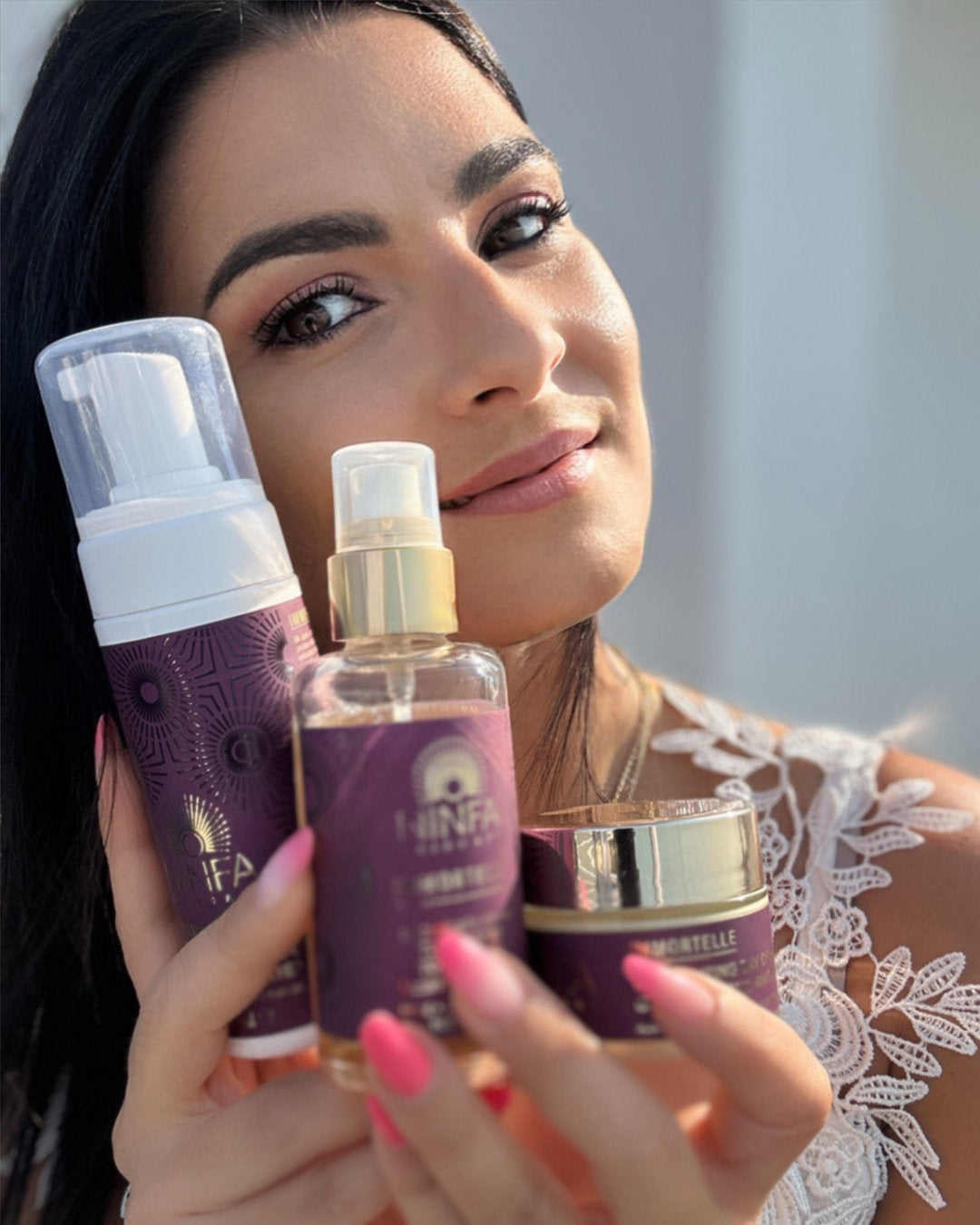 Donna che tiene in mano i prodotti Ninfa Skincare formulati con elicriso, un ingrediente naturale anti-età, parte di una linea di skincare botanica di alta gamma.