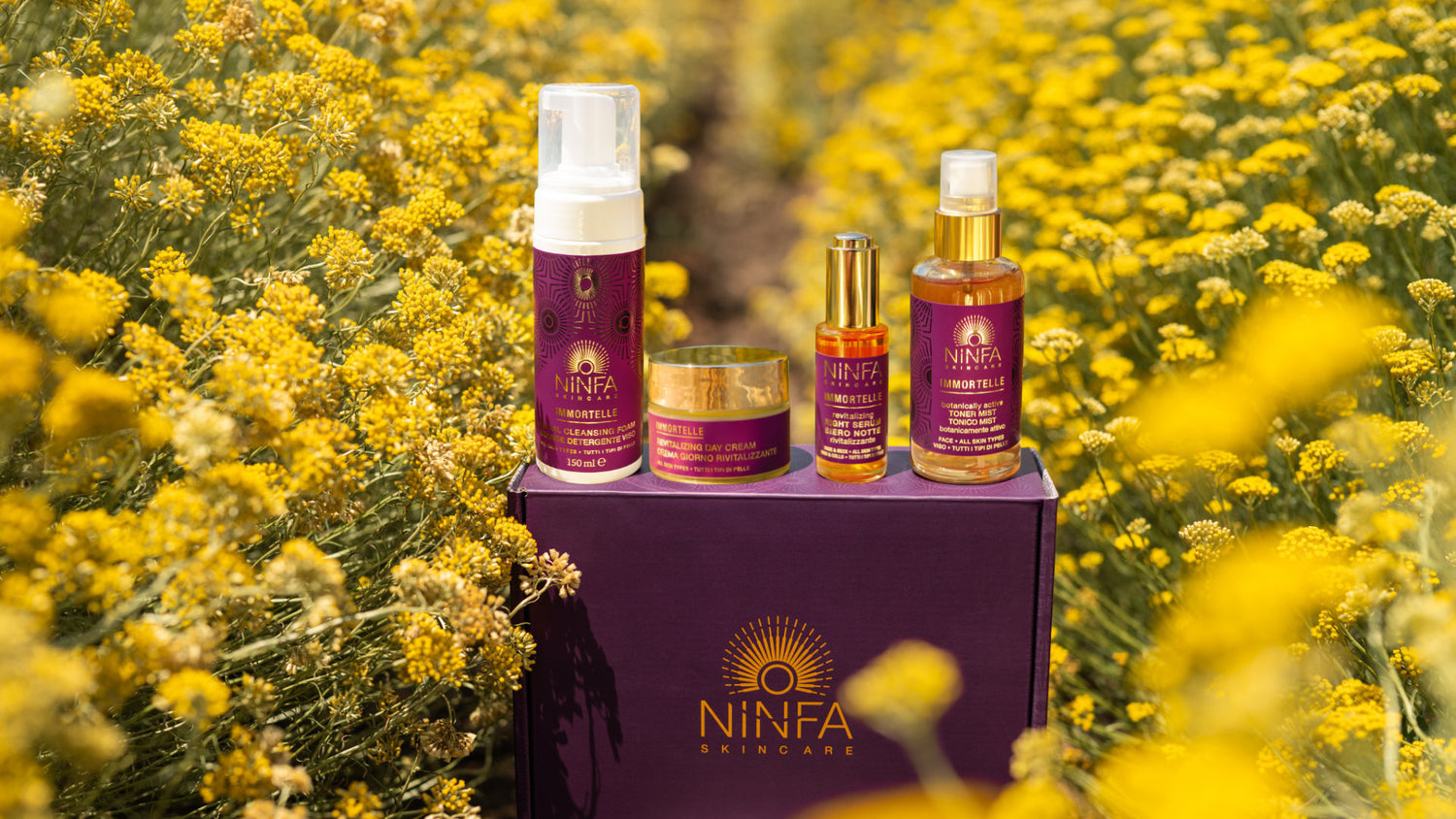 Prodotti skincare naturali Ninfa con Elicriso, esposti su box brandizzata in campo mediterraneo