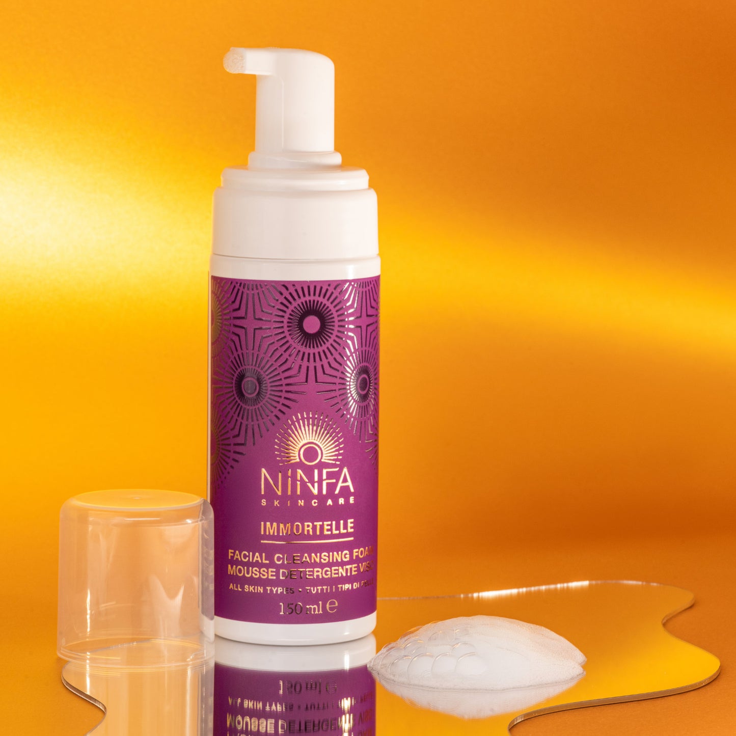 Mousse detergente all’elicriso di Ninfa Skincare su piccolo specchio irregolare, con dettaglio della consistenza