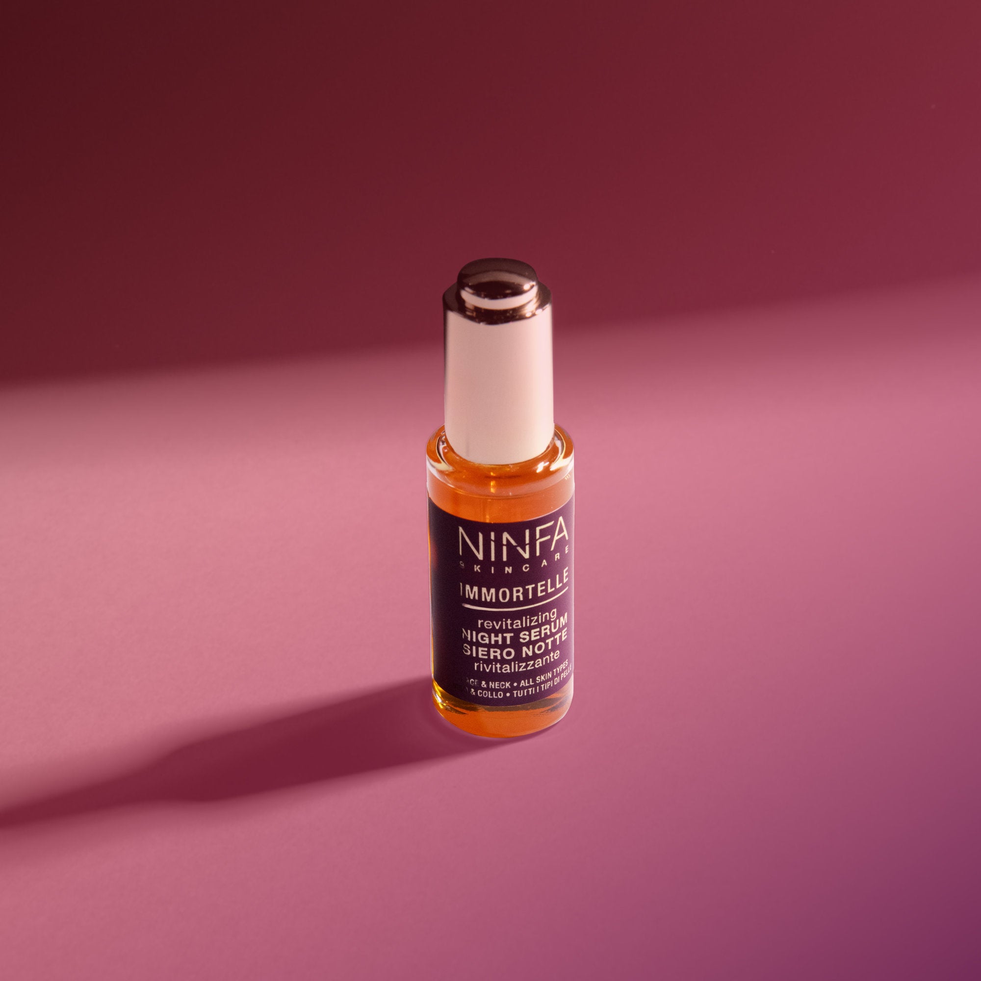 Primo piano del siero all’elicriso di Ninfa Skincare su sfondo rosa scuro