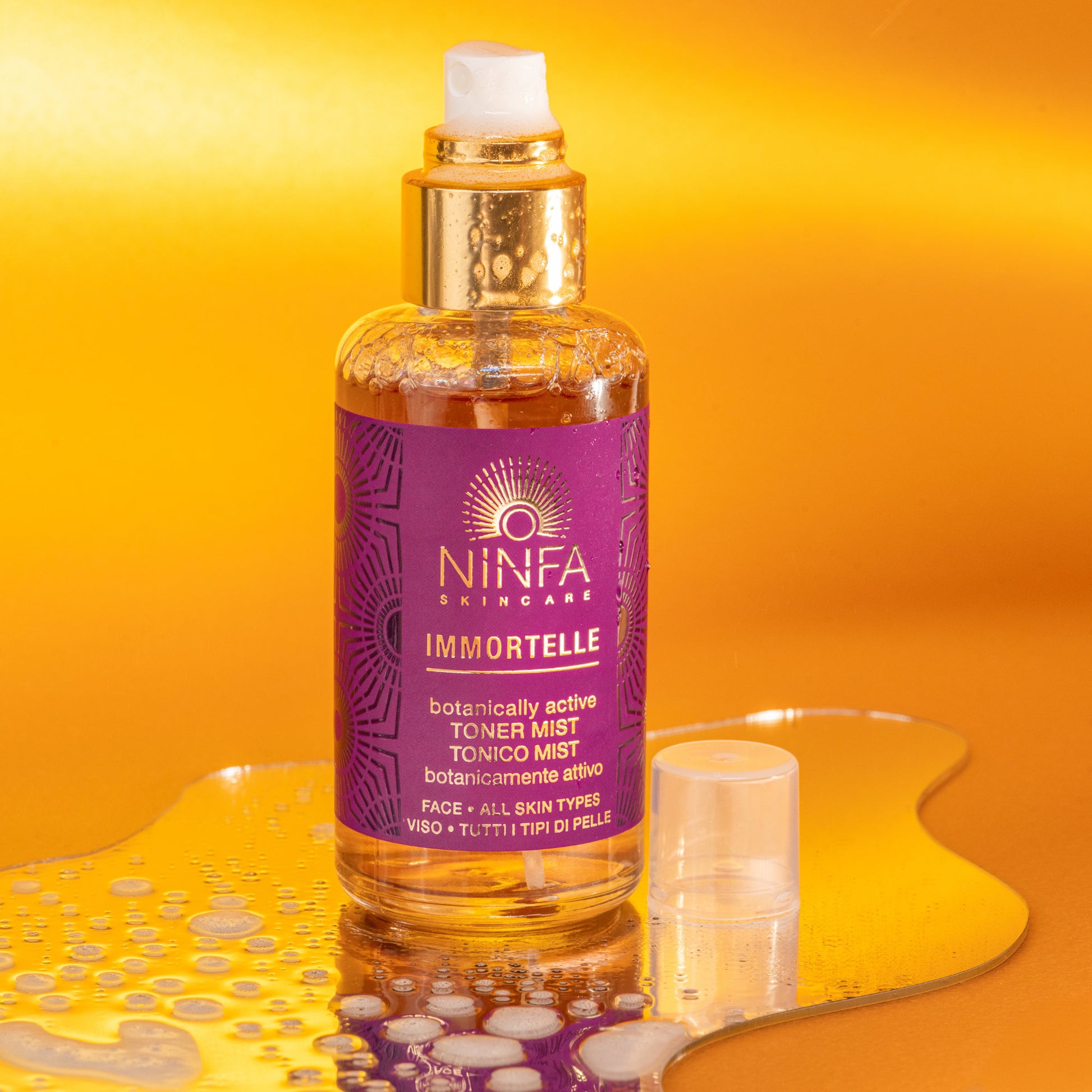 Tonico viso all’elicriso di Ninfa Skincare su piccolo specchio irregolare, con dettaglio della consistenza